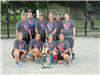 Adult softball players with a trophy