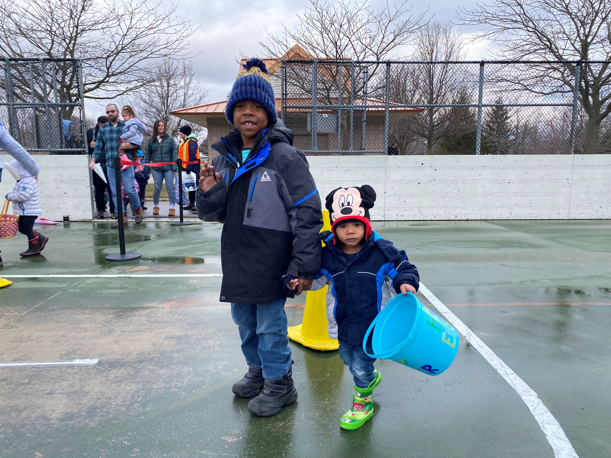 two children wearing blue standing in a park