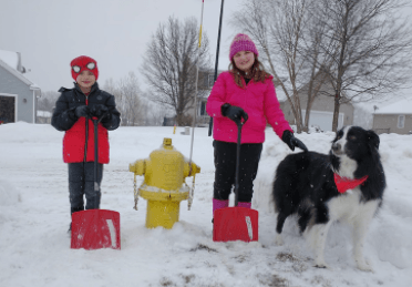 Children posing near fire hydrant in snow