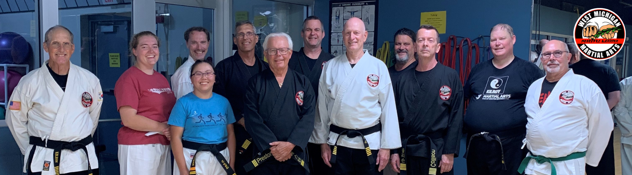 Group of men and women in martial arts gear posing in a group